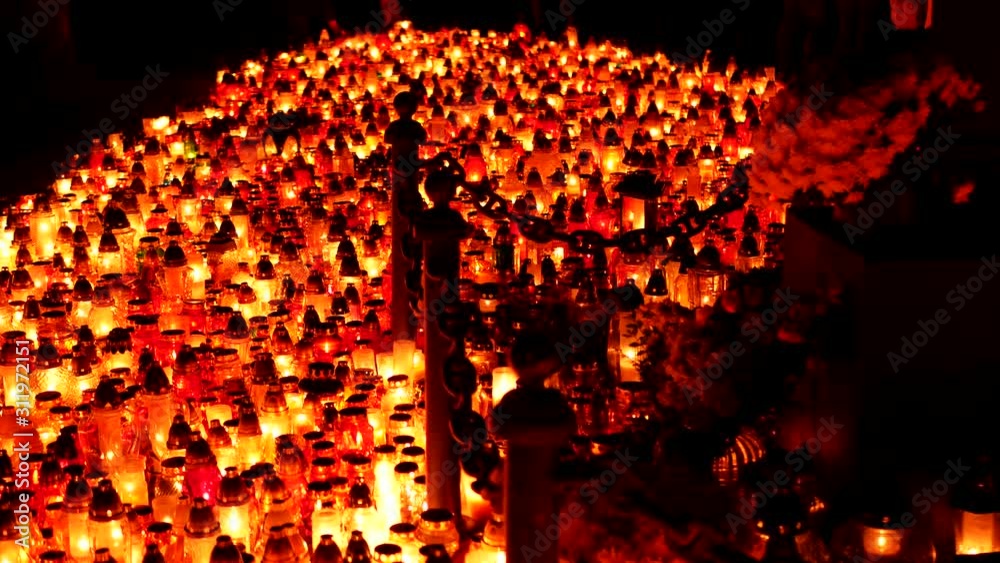 Lots of candles in a cemetery at night. All Saints Day.