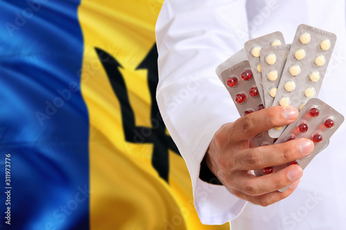 Barbados pharmacy and medicine concept. Doctor holding pills tablet on national flag background. Health theme with copy space for text.