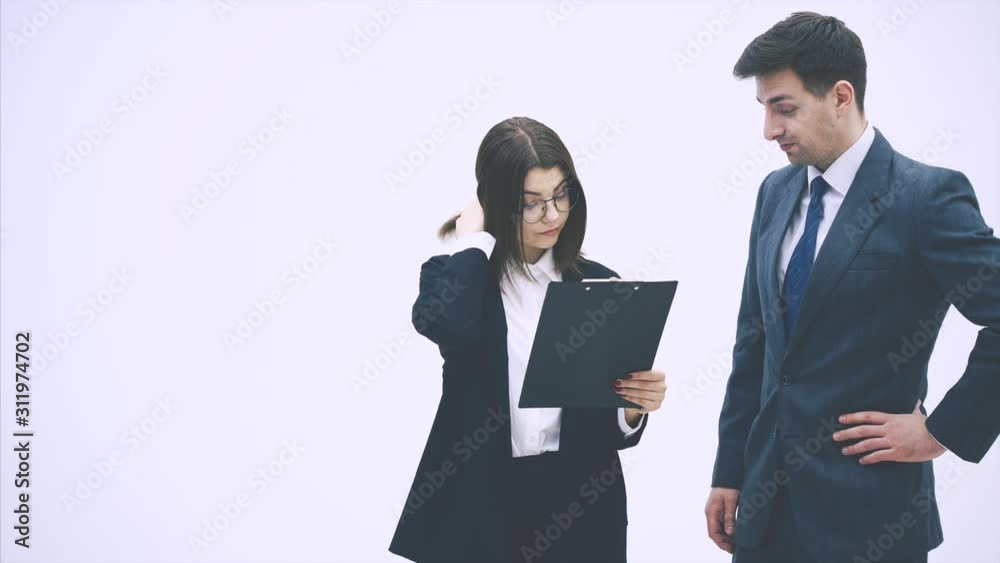 Puzzled business partners holding clipboard with sheet of paper and question mark written on it. They don't understand what it means. Puzzled business partners holding clipboard with sheet of paper and question mark written on it. They don't understand what it means.