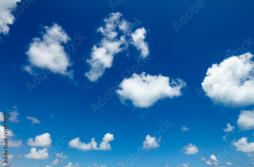 Large white clouds scattered in the blue sky. Cotton-like clouds.