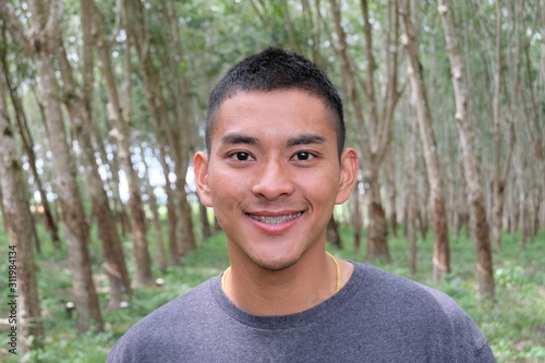 Selective focus young handsome asian man smiling with braces and looking at camera,Portrait of a smiling athletic young Asian man  an early morning,blurred and soft background. 