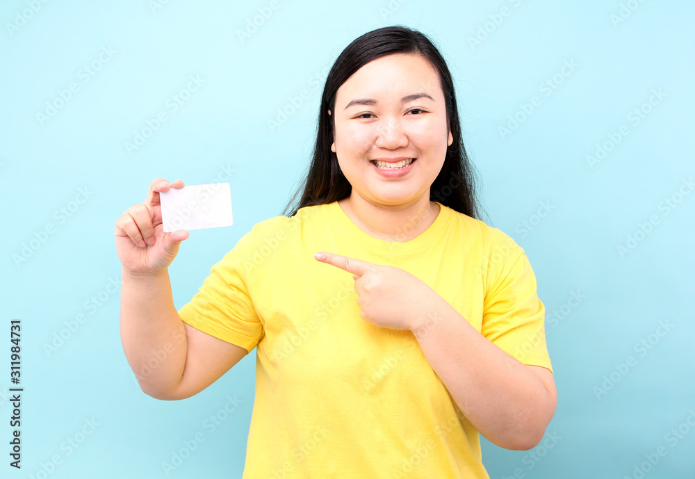 Portrait of happy asian woman holding credit card on a blue background in studio. Portrait of happy asian woman holding credit card on a blue background in studio.
