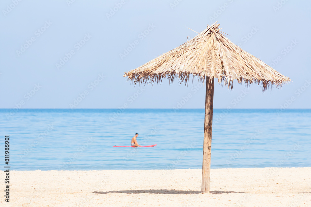 Tropical beach umbrella on the background of the serene sea