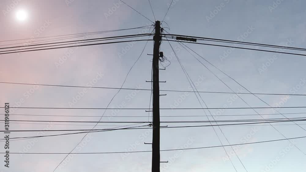 Sun Setting over the Electricity Post and Cables of a Small City. Zoom In. Sun Setting over the Electricity Post and Cables of a Small City. Zoom In.