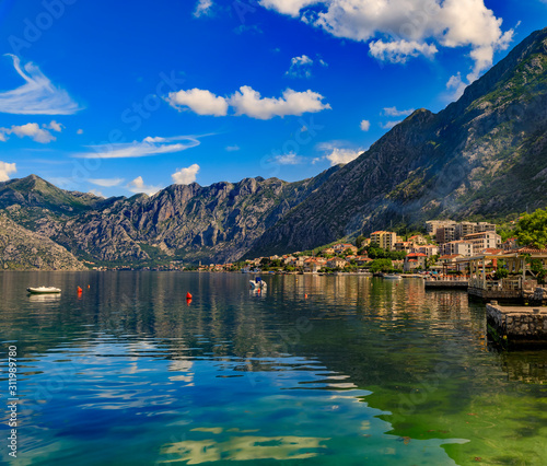 Old stone houses in Kotor Bay with mountains and crystal clear water in the Balkans, Montenegro on the Adriatic Sea