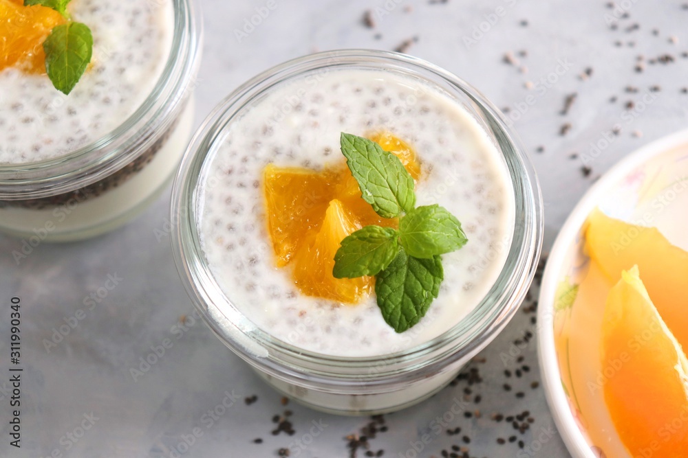 Healthy bowls of yogurt or curd and Chia seeds, topped with chopped oranges and mint leaves. Chia seeds pudding dessert. Healthy bowls of yogurt or curd and Chia seeds, topped with chopped oranges and mint leaves. Chia seeds pudding dessert.