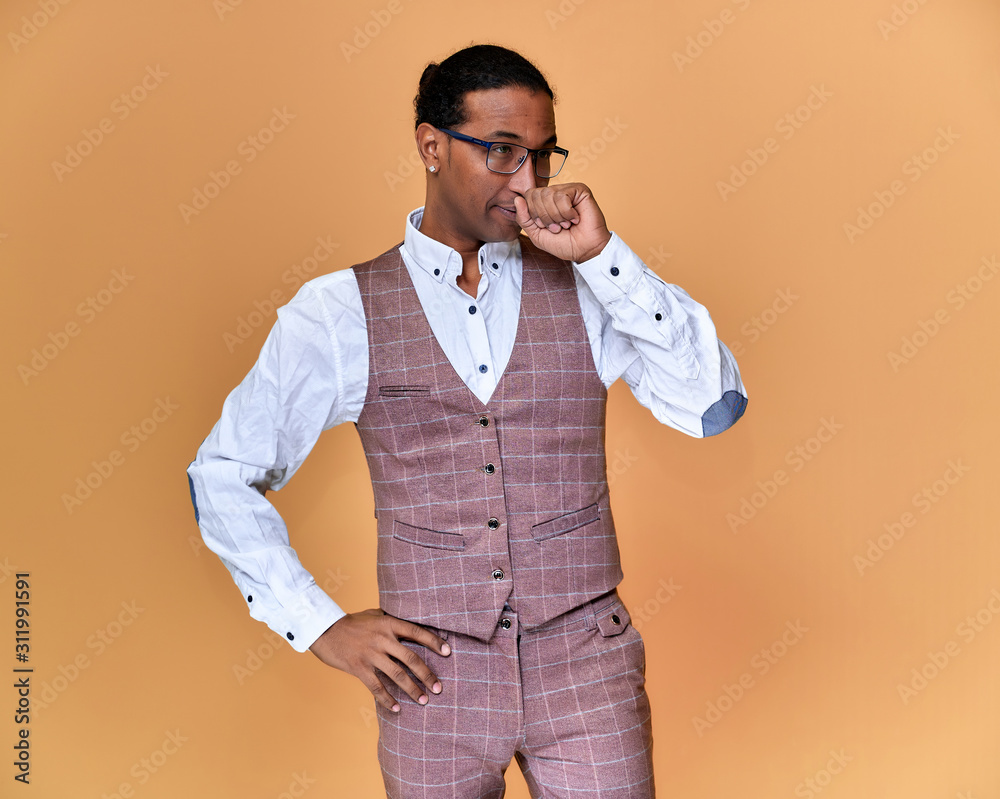 Portrait of a young African American man with short haircuts and a white-toothed smile in a business suit on a pink background. Standing and talking right in front of the camera. Portrait of a young African American man with short haircuts and a white-toothed smile in a business suit on a pink background. Standing and talking right in front of the camera.