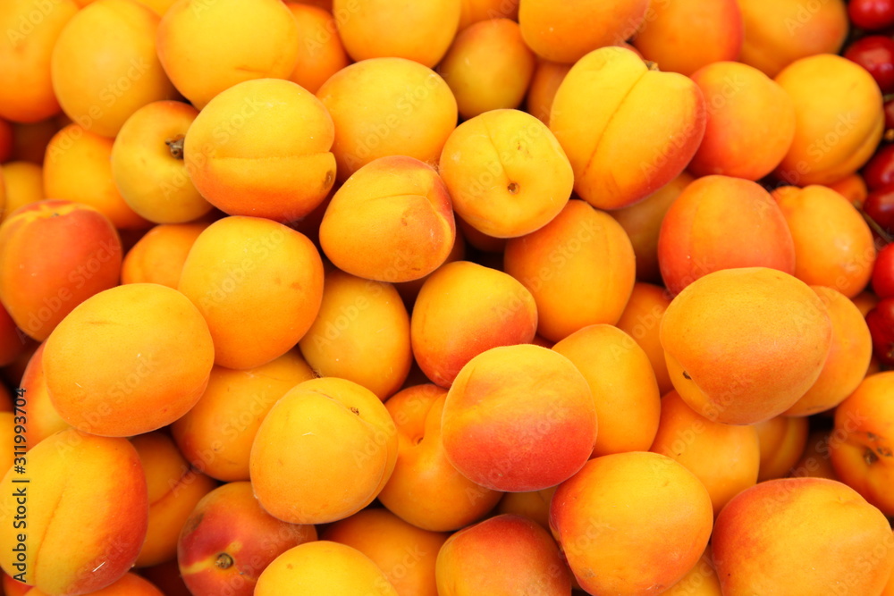 Lots of delicious looking very fresh peaches on sale at an outside market on a sunny Saturday.