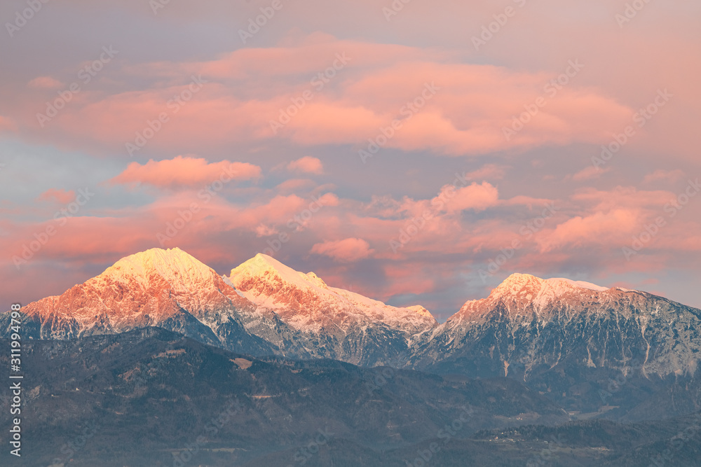 Mountain peeks of Kocna,Grintavec and Kalski greben in Kamnik-Savinja Alps just before the sunset, with the afterglow lit sky viewed from Kranj, Slovenia