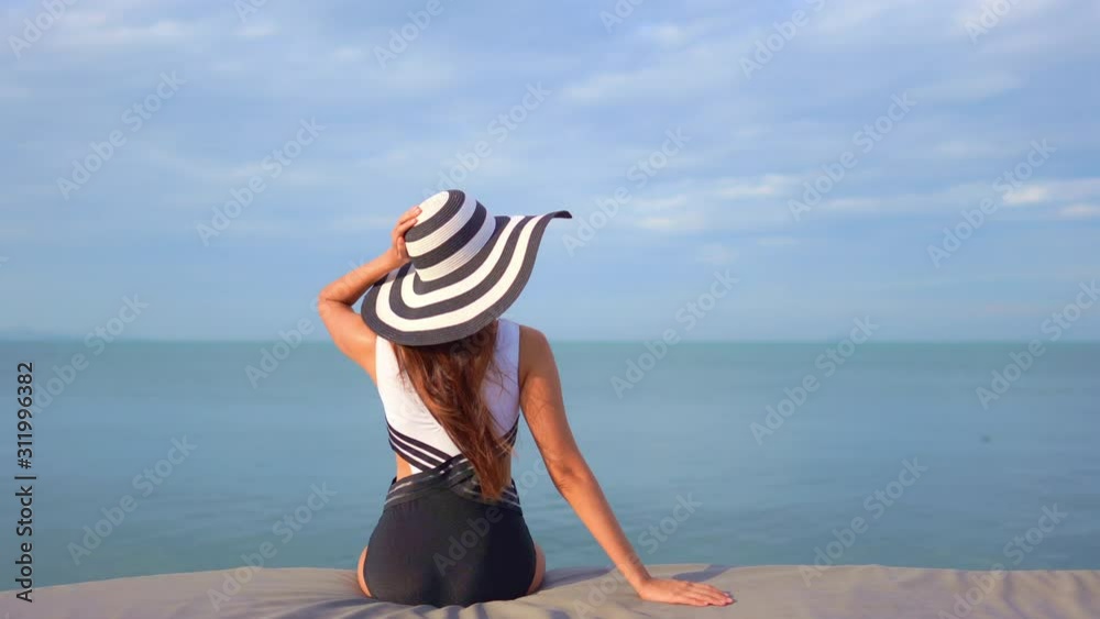 A woman with her back to the camera, dressed in a black and white ...