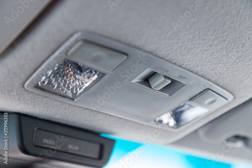 Lighting control inside the car from the top on the instrument panel behind the rear-view mirror in white with buttons