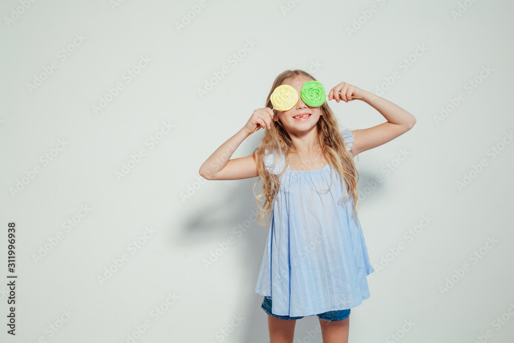 beautiful little girl blonde with cake and candy portrait of food