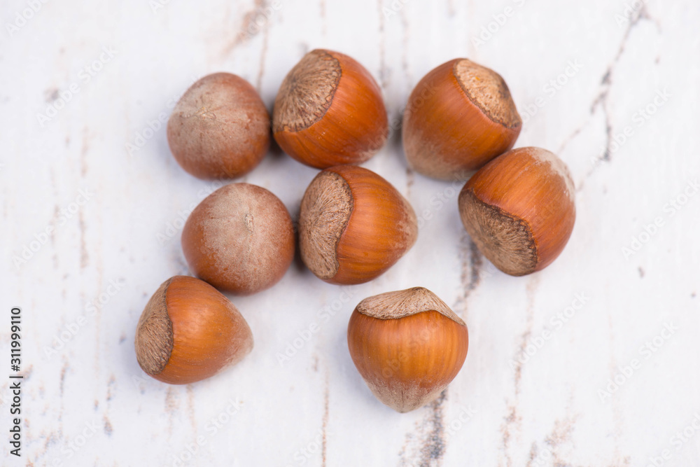 Obraz premium Hazelnuts on a white textrured background, empty copy space