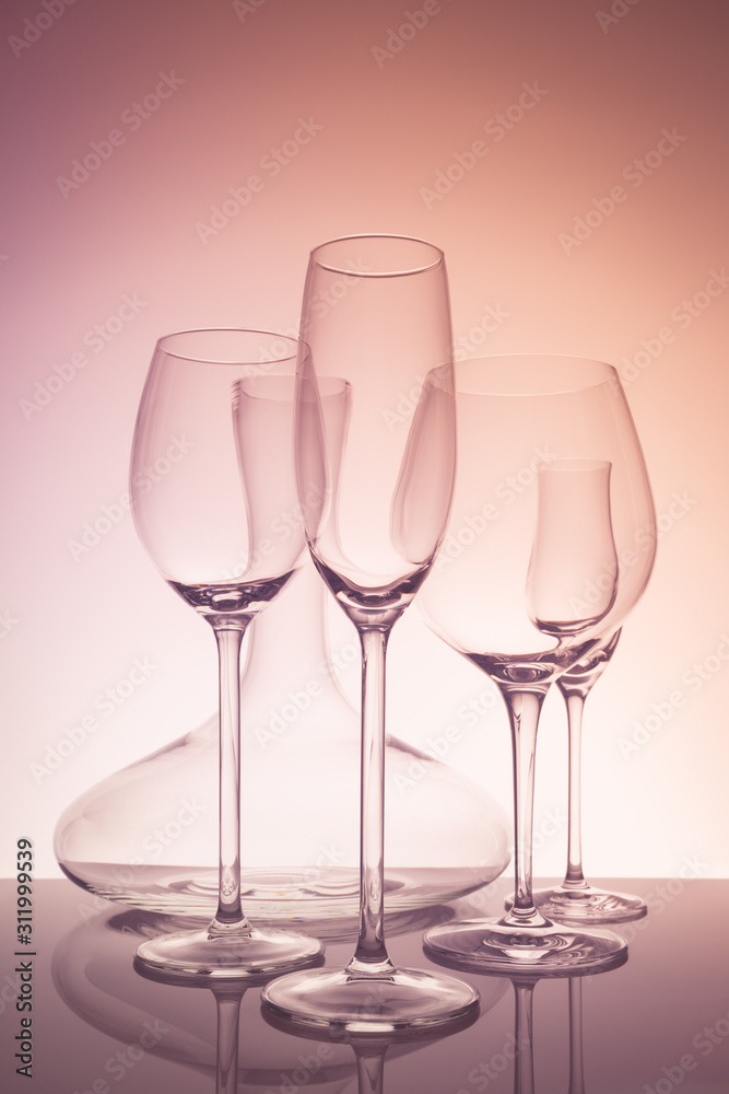 Glassware selection with wine, champagne, liquour glasses and decanter on creative background.. Fine cristal glassware concept. Vertical, warm tone Glassware selection with wine, champagne, liquour glasses and decanter on creative background.. Fine cristal glassware concept. Vertical, warm tone