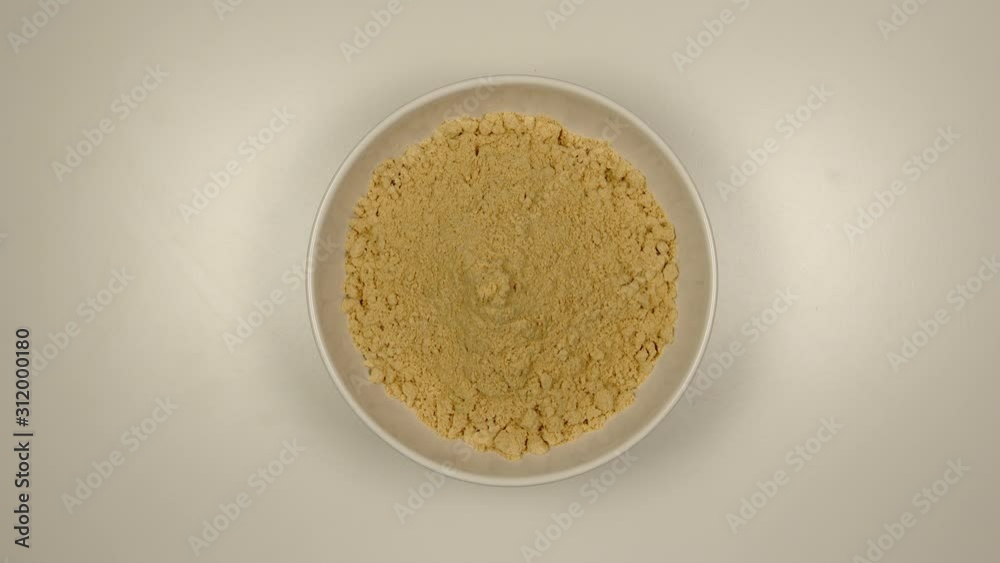 TOP VIEW: Ginger powder fill a white bowl - Stop motion TOP VIEW: Ginger powder fill a white bowl - Stop motion