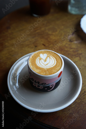 A ceramic mug of hot Latte on wooden table