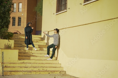 Happy moslem couple take a photo againts yellow buildings background in in the city of Villajoyosa, province of Alicante, Autonomous community of Valencia, Spain