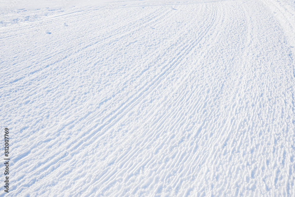rolled ski slope, rilled snowy background