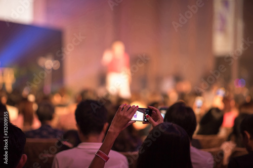 Audience using smart phone technology for take a photo and There is speaker standing in front of the room at the conference hall, Business and Entrepreneurship concept