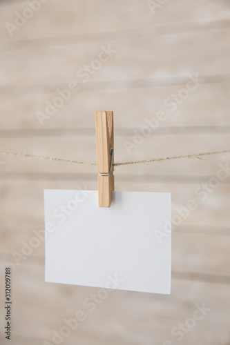 White notice card on the flowers and wooden background.