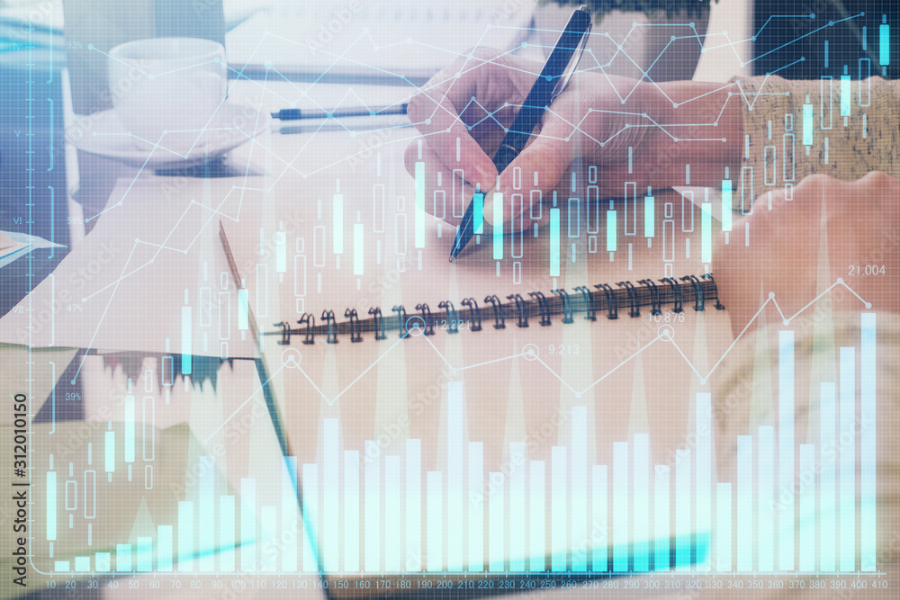 Forex chart hologram on hand taking notes background. Concept of analysis. Double exposure Forex chart hologram on hand taking notes background. Concept of analysis. Double exposure