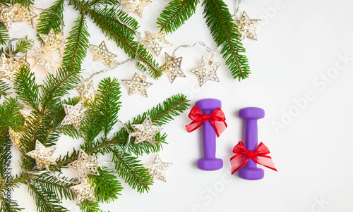 Christmas or New Year on a white background. Diary with the inscription 2020 fitness plan. Composition with dumbbells, lights, fir tree branches for healthy lifestyle and sport photo