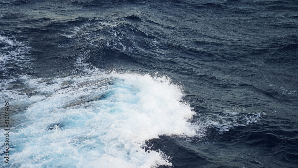 Sea ​​waves in the storm. dark blue water of the Pacific Ocean, white foam on the waves. pure salt water texture