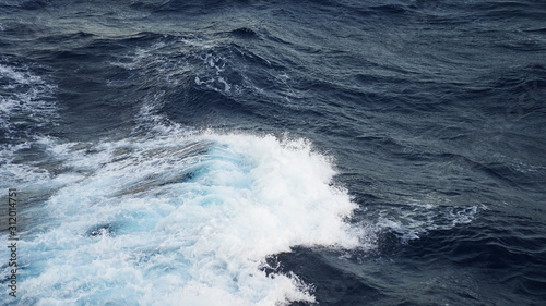 Sea ​​waves in the storm. dark blue water of the Pacific Ocean, white foam on the waves. pure salt water texture