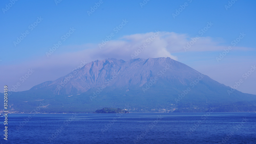 volcano eruption on the japanese islands on a sunny day. an active volcano smokes and throws volcanic dust into the air. Sakurajima volcano