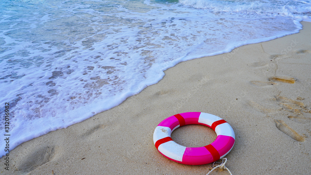 Bright life-saving red-white lifebuoy in the sea floats on the blue waves of the ocean.clear blue water of the pacific ocean. Sea ​​foam