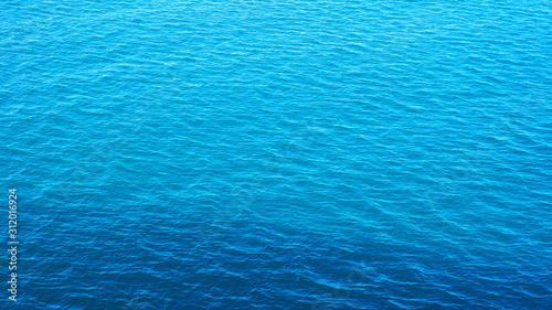 small waves on the surface of the ocean, the texture of calm clear water in the Pacific Ocean of incredible color. turquoise blue sea water. wavy surface. sun reflection