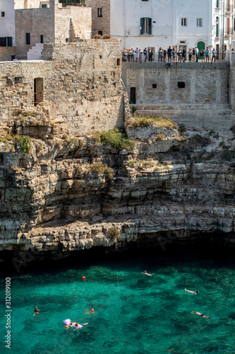 People relax and swimming on lovely beach Lama Monachile in Polignano a Mare, Adriatic Sea, Apulia, Bari province, Italy,