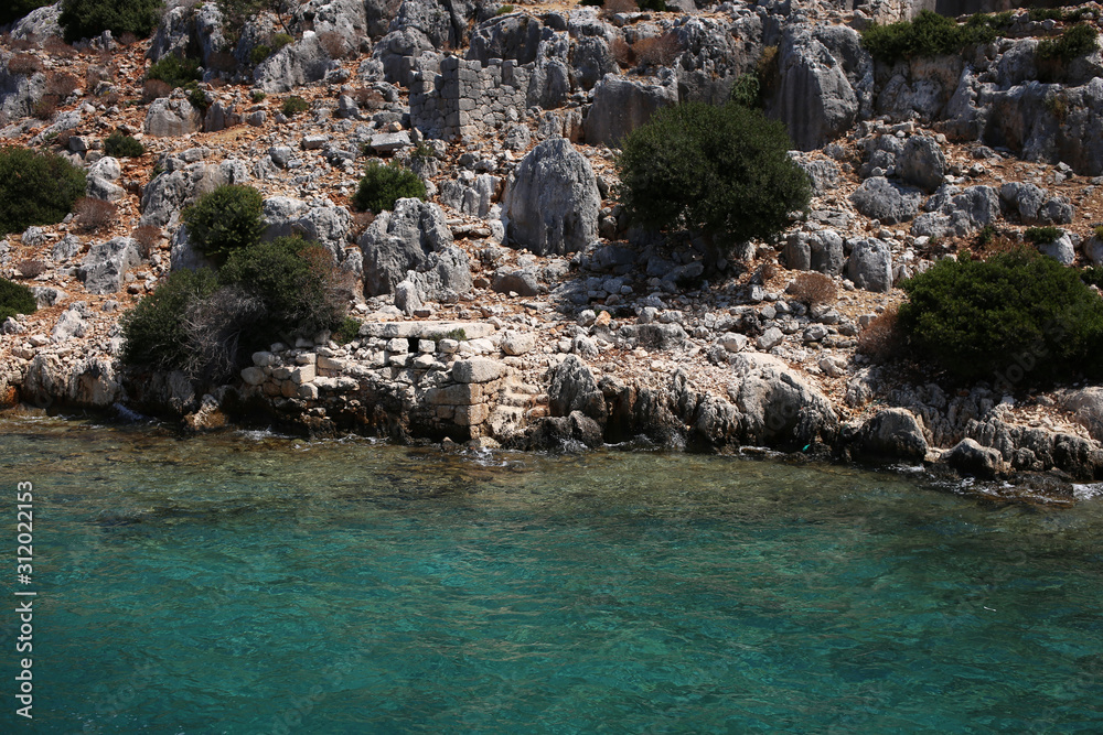 The remains of the foundations of houses, walls of the antique city on the shores of the Kekova island, part of the city drowned under the waters of the Mediterranean Sea due to an earthquake.