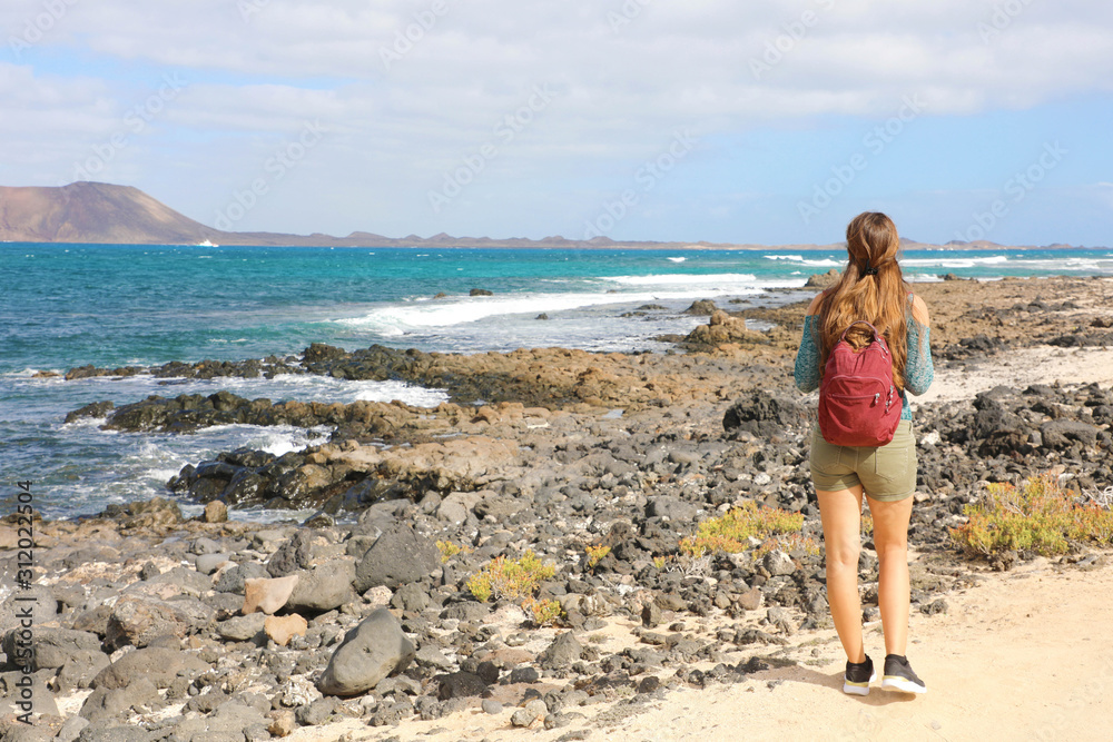 Young female backpacker hiking in Corralejo, Fuerteventura Island