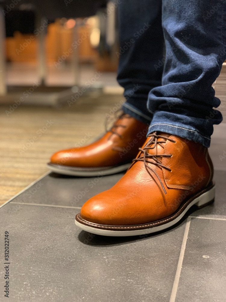 Man wearing blue jeans and pair of brown shoes Stock Photo | Adobe Stock