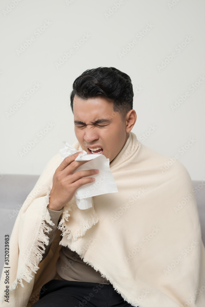 Sick man  blowing nose and sneeze into tissue. Male have flu, virus or allergy respiratory