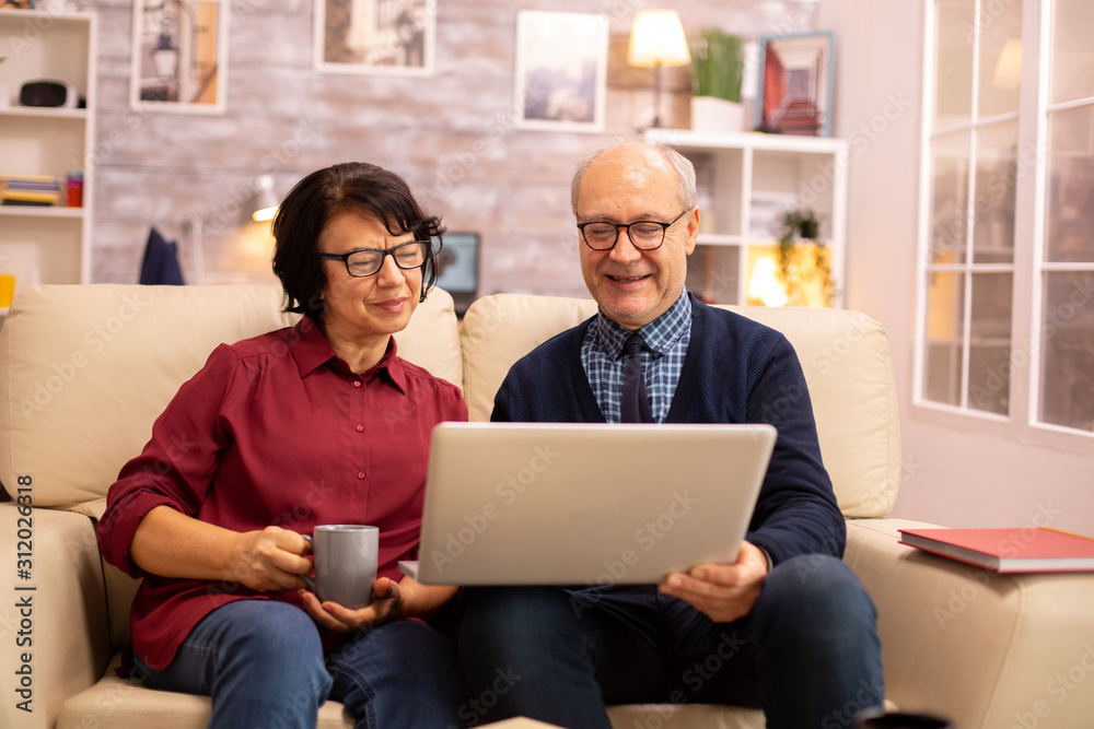 Elderly old couple using modern laptop to chat with their grandson Elderly old couple using modern laptop to chat with their grandson