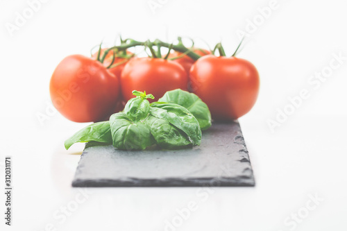 Frische Tomaten, Basilikum auf einem Holzbrett, italienische Vorspeisen kommen immer gut an. 