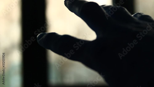 Scary, unknown male palm hand, reaching for light, having pain, be in pain, anger, agony. photo