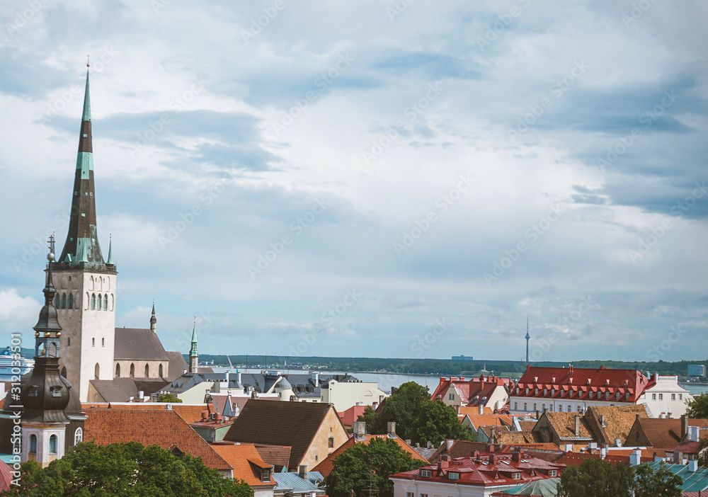 Aerial cityscape with medieval old town, St. Olav's Baptist church and Tallinn city wall in the morning, Tallinn, Estonia. Medieval walled city in the early autumn in the Baltic Sea region in Northern