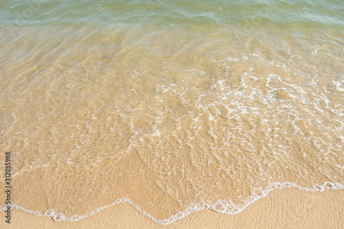 Close up golden sand and sea wave background texture with copy space, White sand beach, Blue sea wave landscape, summer holidays concept, vacations on tropical island