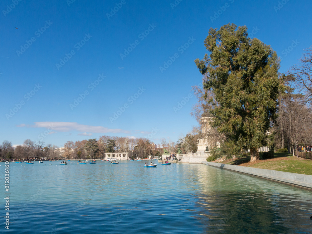 Beautiful picture of tourists on boats at pond of the Parque del Buen Retiro - Park of the Pleasant Retreat in Madrid, Spain Beautiful picture of tourists on boats at pond of the Parque del Buen Retiro - Park of the Pleasant Retreat in Madrid, Spain