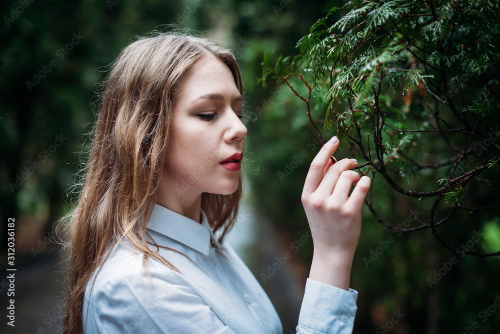 portrait of young blonde woman in a white blouse at the tree portrait of young blonde woman in a white blouse at the tree