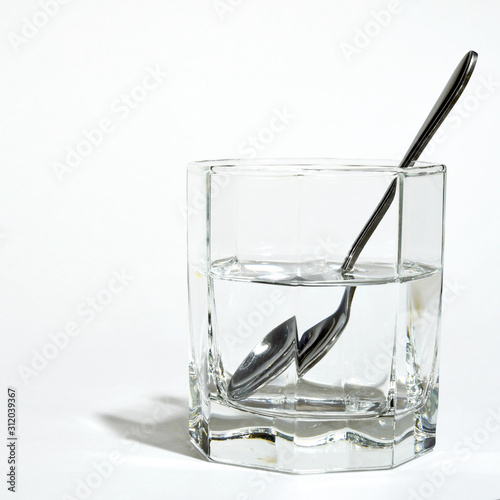 steel spoon in a glass with clear water