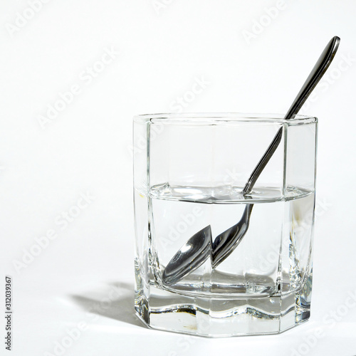steel spoon in a glass with clear water © nikolych