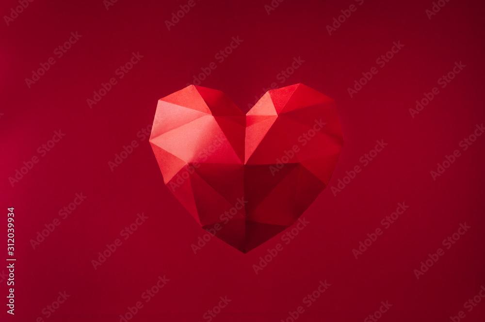 Paper geometric heart on red background with copyspace Paper geometric heart on red background with copyspace