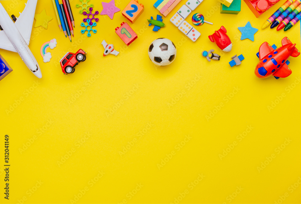 Frame of kids toys on yellow background with copy space - obrazy, fototapety, plakaty 