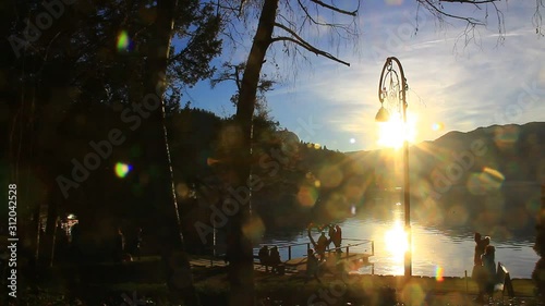 People walking near the lake. Silhouettes of people. Shadows. Sunset time.