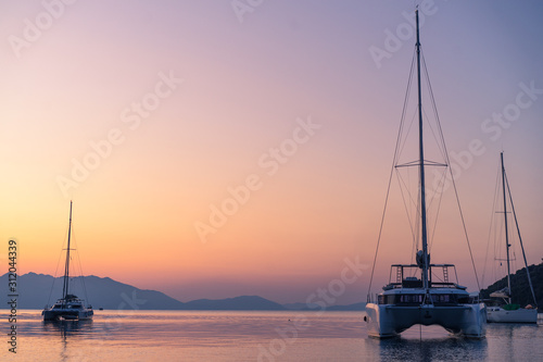 Scenic beautiful sunrise with a view on a boat at the marine of Epidaurus Island, Peloponnese, Saronic Gulf, Greece. 