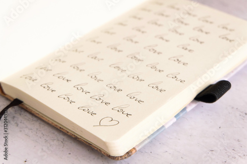 close up of a notebook full of the word love many times